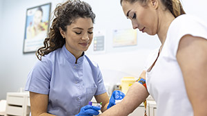 medical technologist doing blood draw services patient lab assistant with sterile rubber gloves taking blood sample from patient medical technologist doing blood draw services patient lab assistant with sterile rubber gloves taking blood sample from patient