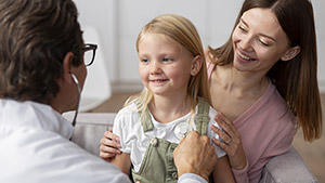 young girl with her mother doctors office physical examination young girl with her mother doctors office physical examination